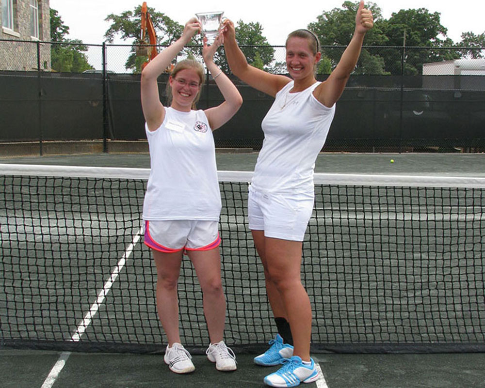 My doubles partner and I celebrate with our trophy